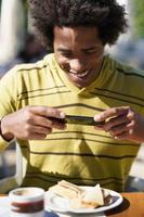 Cubaanse zwarte maakt een foto met zijn smartphone naar een snack