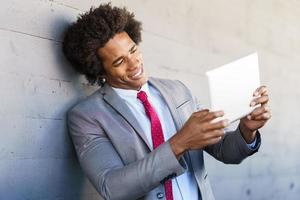 zwarte zakenman met behulp van een digitale tablet in stedelijke achtergrond foto