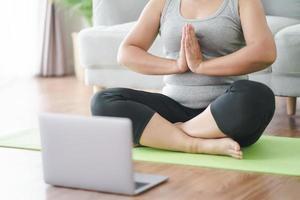 mollige dikke vrouw beoefent online yoga op laptop.