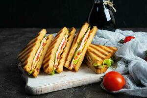 club belegd broodje met ham, tomaat, groen en kaas. gegrild panini foto