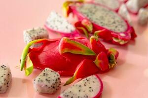 plakjes van vers wit pitaya of draak fruit Aan roze achtergrond, vlak leggen foto