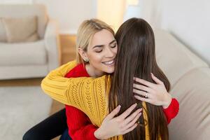 openhartig verschillend meisjes het beste vrienden omarmen staand binnenshuis, dichtbij omhoog tevreden Dames gezicht genieten inschrijving moment gemist blij naar zien elk andere na lang scheiding, vriendschap warm relaties concept foto