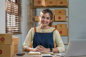 portret van aziatische jonge vrouw mkb werkend met een doos thuis de werkplek. start-up kleine ondernemer, kleine ondernemer mkb of freelance bedrijf online en leveringsconcept. foto