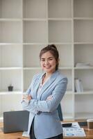 zelfverzekerd Aziatisch zakenvrouw staand in kantoor, op zoek Bij camera met professioneel gedragswijze. modern Aziatisch bedrijf professioneel. foto