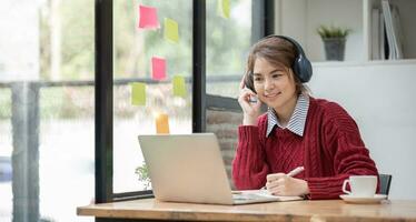 Aziatisch vrouw leerling studie online in klas, studie online, vervelend koptelefoon, aan het kijken video telefoongesprek, zoomen, gelukkig Aziatisch vrouw aan het leren taal online met computer laptop. foto