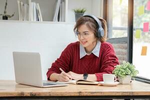 Aziatisch vrouw leerling studie online in klas, studie online, vervelend koptelefoon, aan het kijken video telefoongesprek, zoomen, gelukkig Aziatisch vrouw aan het leren taal online met computer laptop. foto