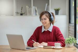 Aziatisch vrouw leerling studie online in klas, studie online, vervelend koptelefoon, aan het kijken video telefoongesprek, zoomen, gelukkig Aziatisch vrouw aan het leren taal online met computer laptop. foto