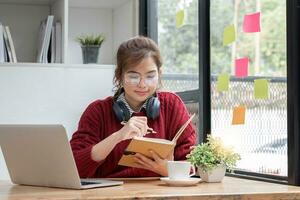 Aziatisch vrouw leerling studie online in klas, studie online, vervelend koptelefoon, aan het kijken video telefoongesprek, zoomen, gelukkig Aziatisch vrouw aan het leren taal online met computer laptop. foto