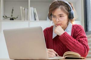 jong vrouw aan het studeren online Aan laptop Bij huis. foto