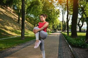 charmant jong Afrikaanse Amerikaans sportvrouw, vastbesloten atleet uitrekken haar poten, opwarming omhoog haar lichaam voordat lichaam gewicht training buitenshuis in stad park foto