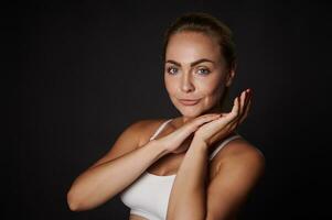 mooi Kaukasisch midden- oud vrouw met perfect schoon gezond huid en natuurlijk bedenken vol vertrouwen op zoek Bij camera, geïsoleerd over- zwart achtergrond met kopiëren ruimte voor advertenties foto