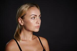 mooi prachtig Jaren 30 jong Kaukasisch blond vrouw op zoek Bij camera geïsoleerd Aan zwart. detailopname schoonheid portret. gezond huid, lichaam zorg, schoonheid behandeling, schoonheidsspecialiste concept foto