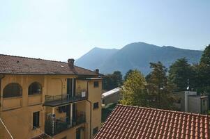 op het dak van oud stijl gebouwen in middeleeuws stad- kanzo in Lombardije, tegen de achtergrond van Alpen. reizen en toerisme. foto