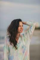 portret van gelukkig vrouw Aan de strand in avond. foto