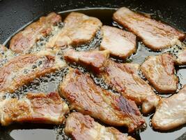 gebakken varkensvlees in pan, dichtbij omhoog foto