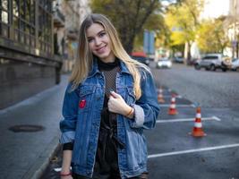 schattig lachend meisje met luxe haar in een spijkerjasje foto