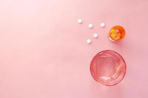 witte kleur medische pillen morsen op roze, bovenaanzicht foto