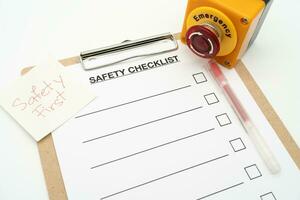 veiligheid eerste tekst Opmerking. blanco checklist papier gedurende veiligheid audit en risico verificatie. veiligheid checklist het formulier met noodgeval hou op knop. foto
