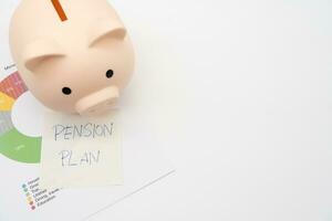concept van pensioen planning. een varkentje bank met papier Notitie pensioen plan. varkentje bank en diagram voor geld beheer in de toekomst. foto