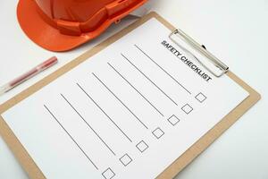 blanco checklist papier gedurende veiligheid audit en risico verificatie. veiligheid checklist het formulier met moeilijk hoed of veiligheid hoed. foto