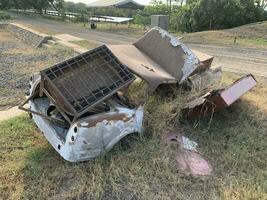 gebroken en roestig auto was geparkeerd in een leeg veel voor een lang tijd zo het was overwoekerd met gras foto