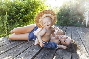 baby jongen en zijn moeder hebben pret Aan terras foto