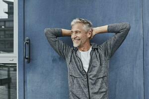 portret van lachend volwassen Mens in voorkant van Sportschool foto