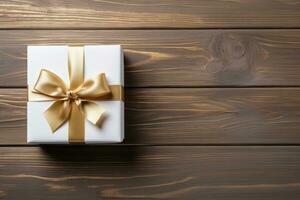 geschenk doos met gouden lint en boog Aan de houten tafel top. vakantie geschenk met verjaardag of Kerstmis Cadeau, top visie. foto
