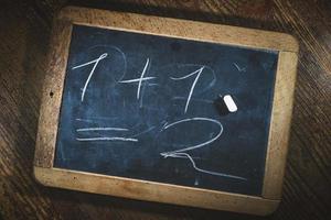 klein schoolbord met eenvoudige wiskundige berekening voor kinderen foto