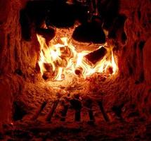 rood vuur van plakhout, donkergrijze zwarte kolen in metalen vuurpot foto