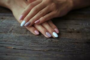 Dames is handen met een mooi manicure Aan een houten achtergrond . herfst tendens, Pools beige en wit polka dots Aan nagels met gel Pools, schellak. foto