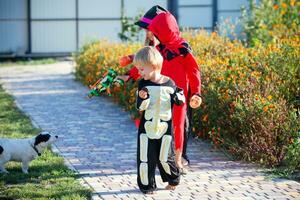 kinderen in halloween kostuums doen alsof naar schieten een hond. foto