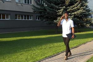 gelukkige afrikaanse amerikaan met een telefoon op straat foto