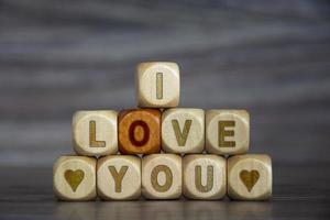 woord ik hou van je op houten kubussen op onscherpe achtergrond. verklaring. foto