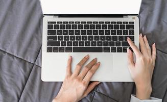 vrouwenhand die laptop voor zaken online thuis gebruikt at foto