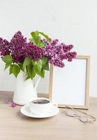 boeket lila bloemen in een vaas en leeg houten frame