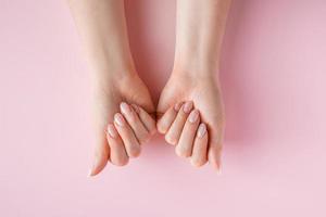 huidverzorgingsconcept. mooie vrouwelijke handen op roze achtergrond foto