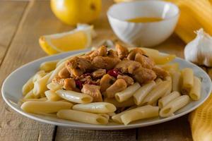 Mediterraans eten - penne pasta en kip in een romige saus foto
