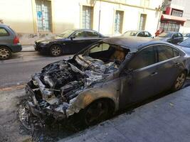 verbrand auto Aan stad straat foto