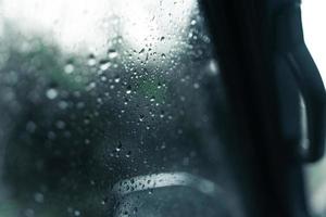 waterdruppels op de voorruit van de auto op regenachtige dag foto