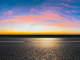 leeg asfalt weg en mooi lucht Bij zonsondergang, panoramisch visie. foto