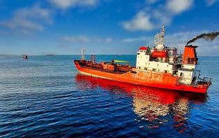 zeegezicht met een rood schip op een blauwe zeeachtergrond foto