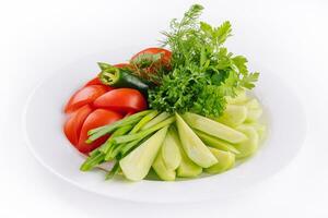 veganistisch bord van vers gesneden komkommers, groen uien en kers tomaten foto