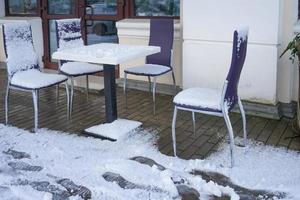 straatcafé met tafels en stoelen in de sneeuw. foto