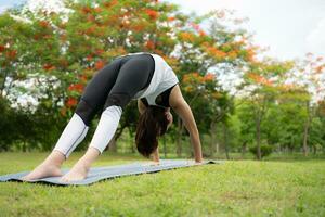 jong vrouw met buitenshuis activiteiten in de stad park, yoga is haar gekozen werkzaamheid. foto