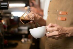 barista gieten koffie in een kop in koffie winkel, detailopname foto