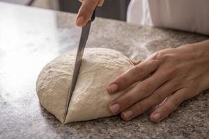 vrouw handen snijden pizzadeeg close-up foto