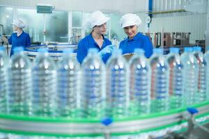 drinken water fabriek arbeider Bij een productie lijn van drinken water fabriek foto