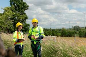 ingenieur en arbeider bespreken de project Aan de achtergrond van wind turbines foto