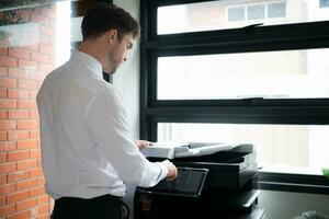 zakenman in kantoor werken met kopieerapparaat. foto